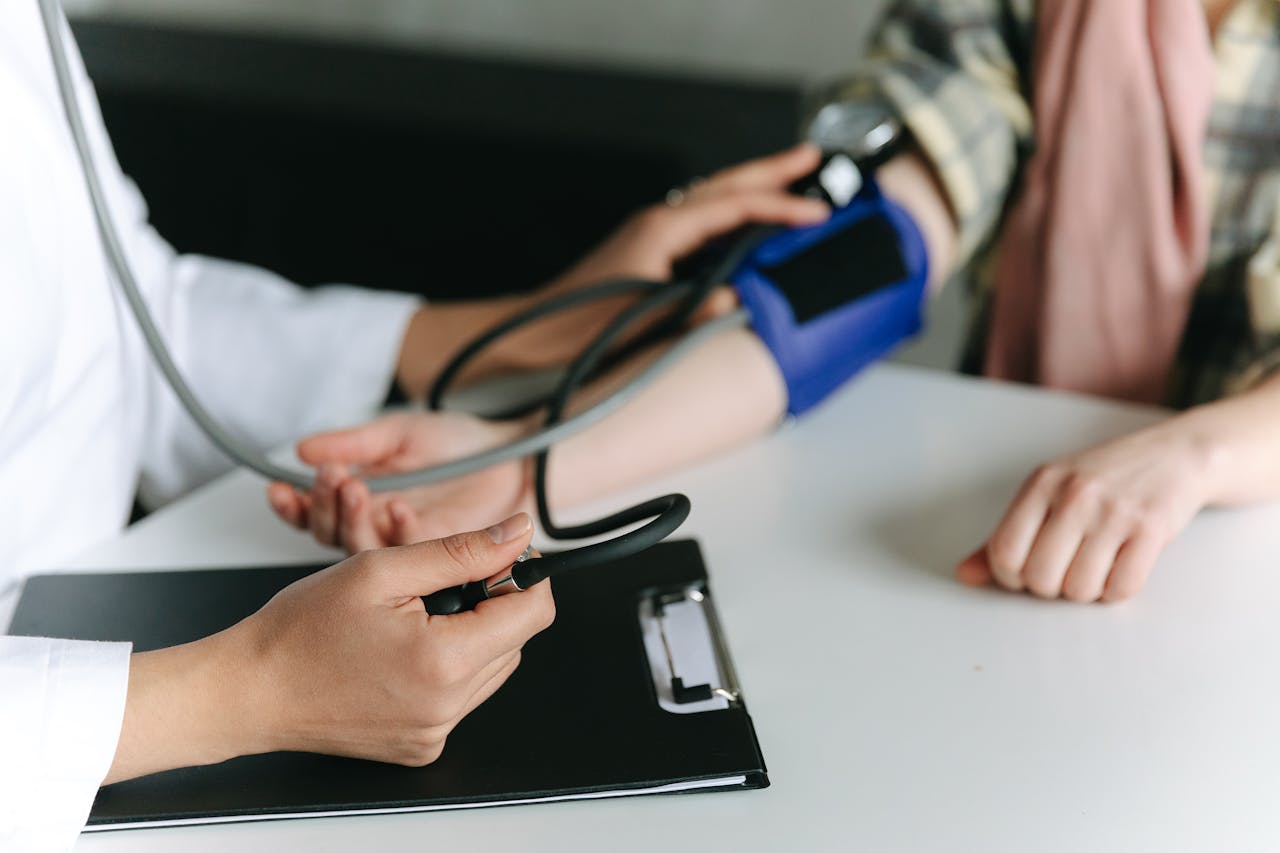 Close-up of a medical professional measuring a patients blood pressure at a clinic.